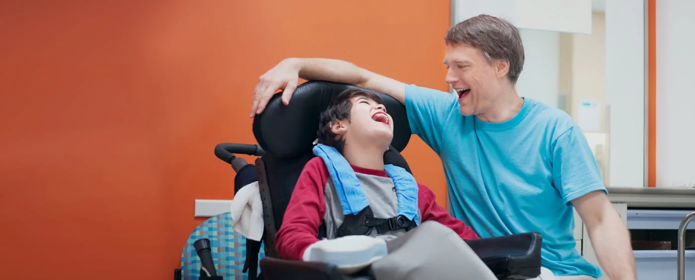 Uśmiechnięte dziecko z rodzicem podczas rehabilitacji w ramach terapii komórkami macierzystymi