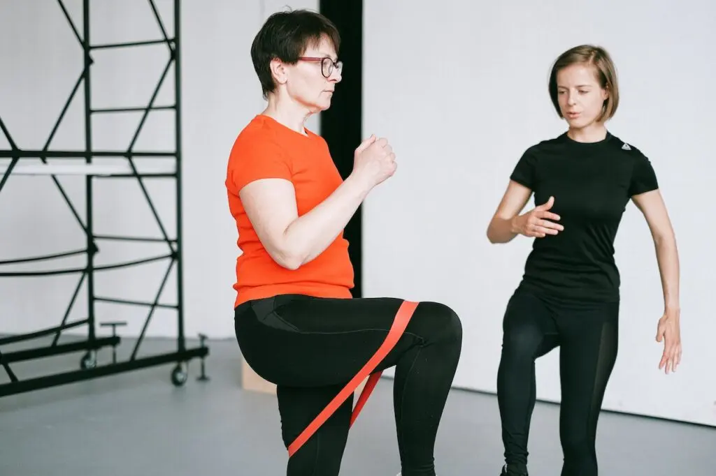 Fizjoterapeuta asystujący pacjentowi przy ćwiczeniach z taśmą oporową